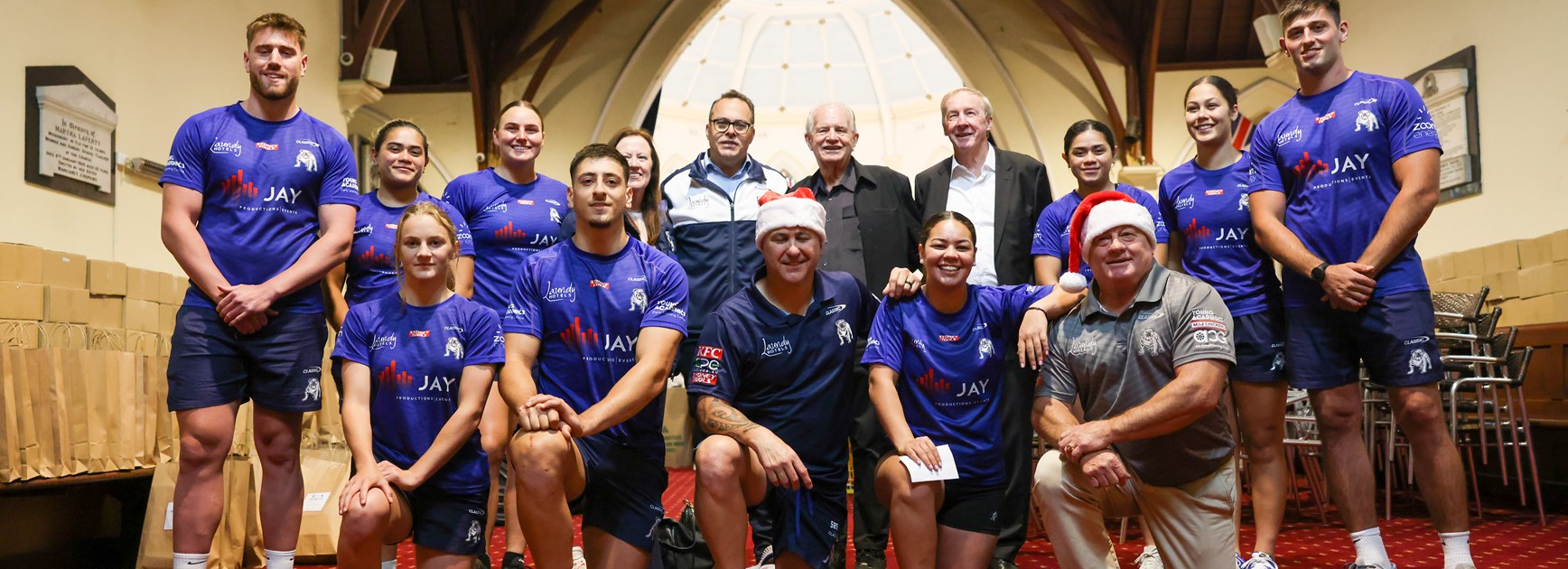Canterbury League Club and Bulldogs Chairman with Bulldogs players and staff together with Rev. Bill Crews in support of a Christmas Food Drive Appeal.